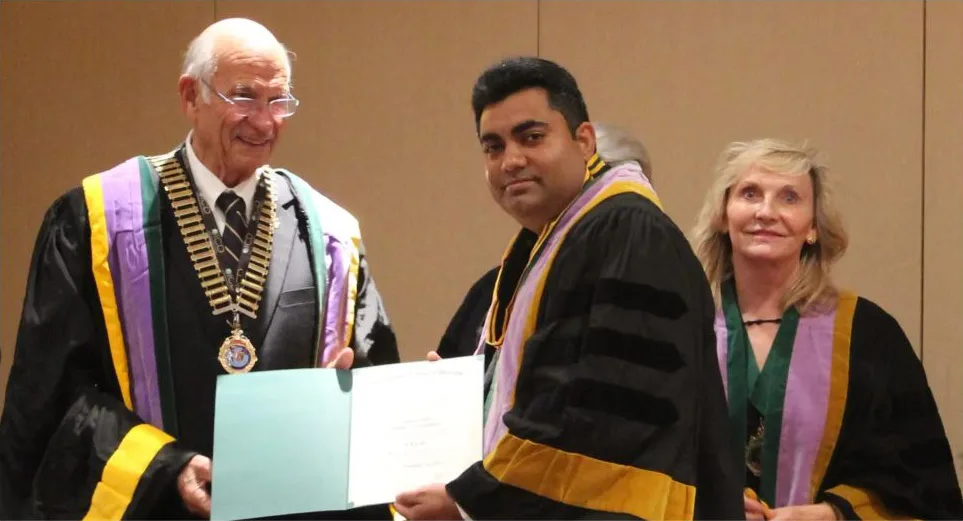 Dr. Lalla receiving a fellowship certificate at a graduation ceremony